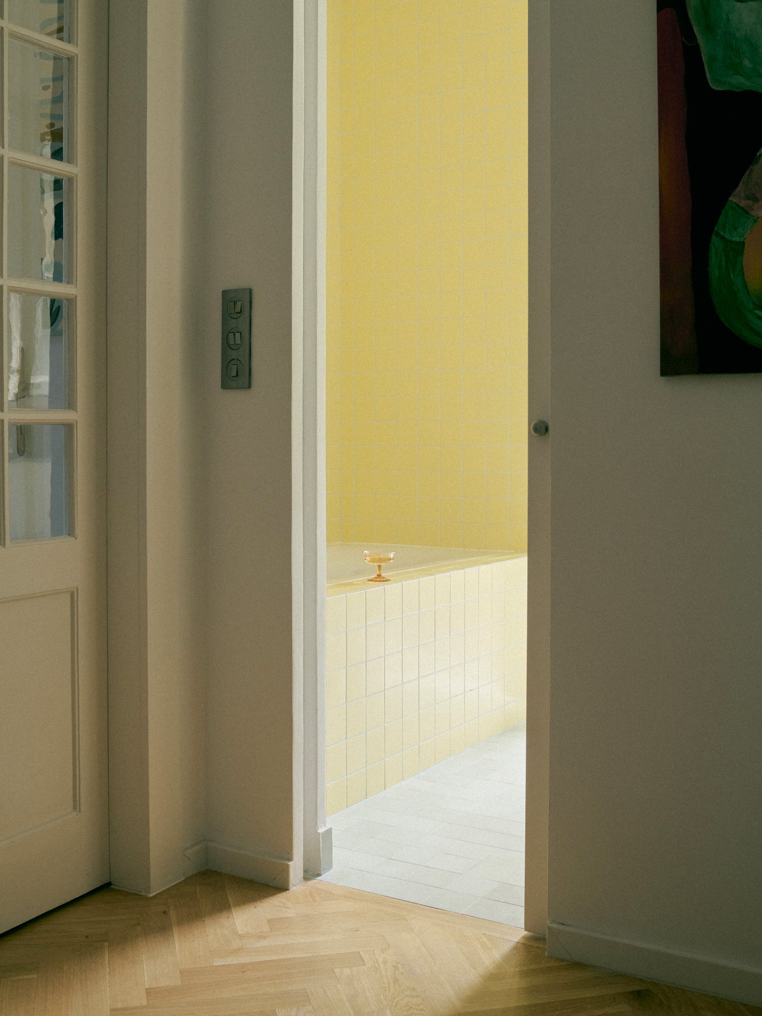 Yellow bathroom seen through an open door in the B6 apartment