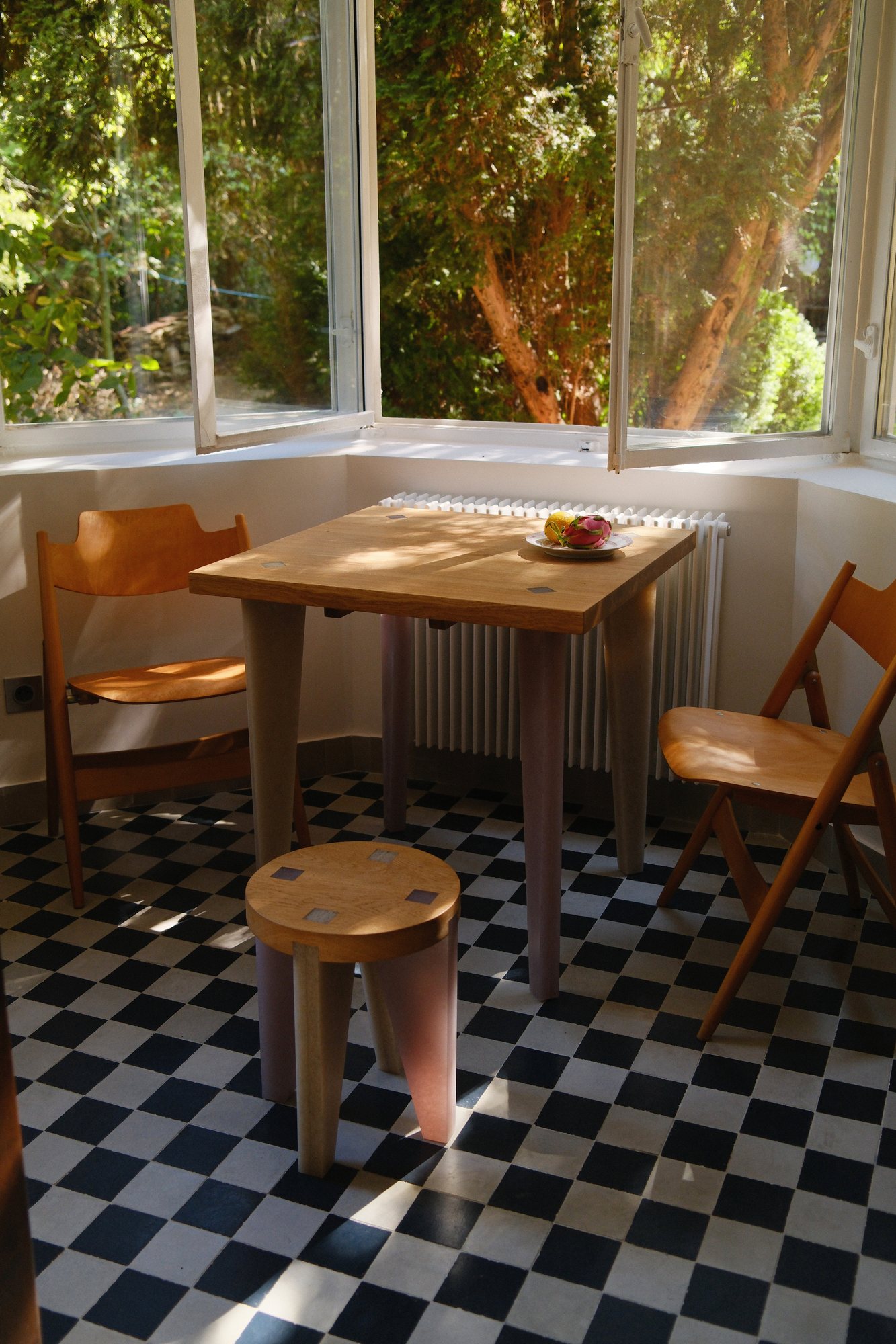 NANO Stool beside a café table on a checkerboard floor
