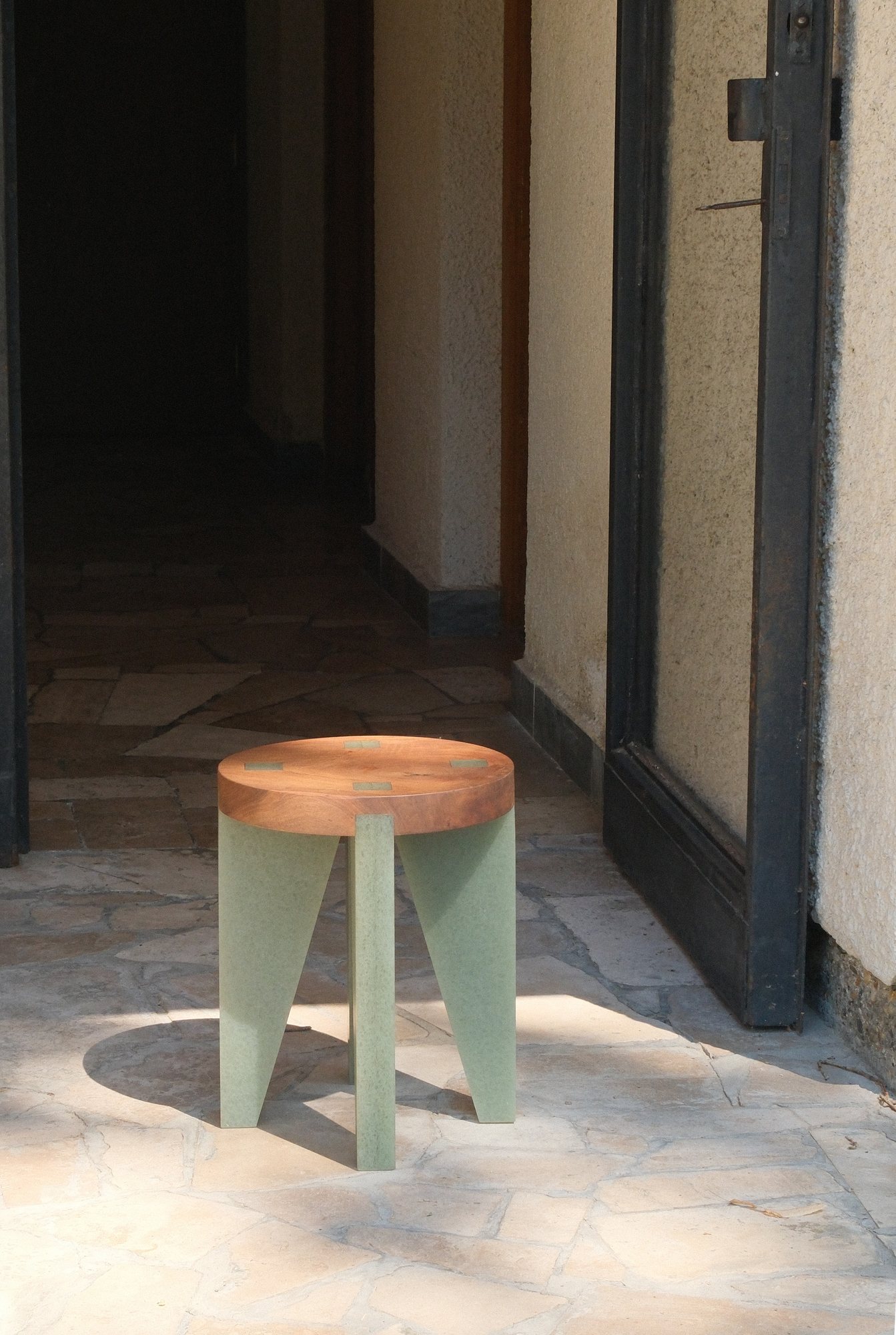 NANO Stool with a walnut seat and green legs in a hallway